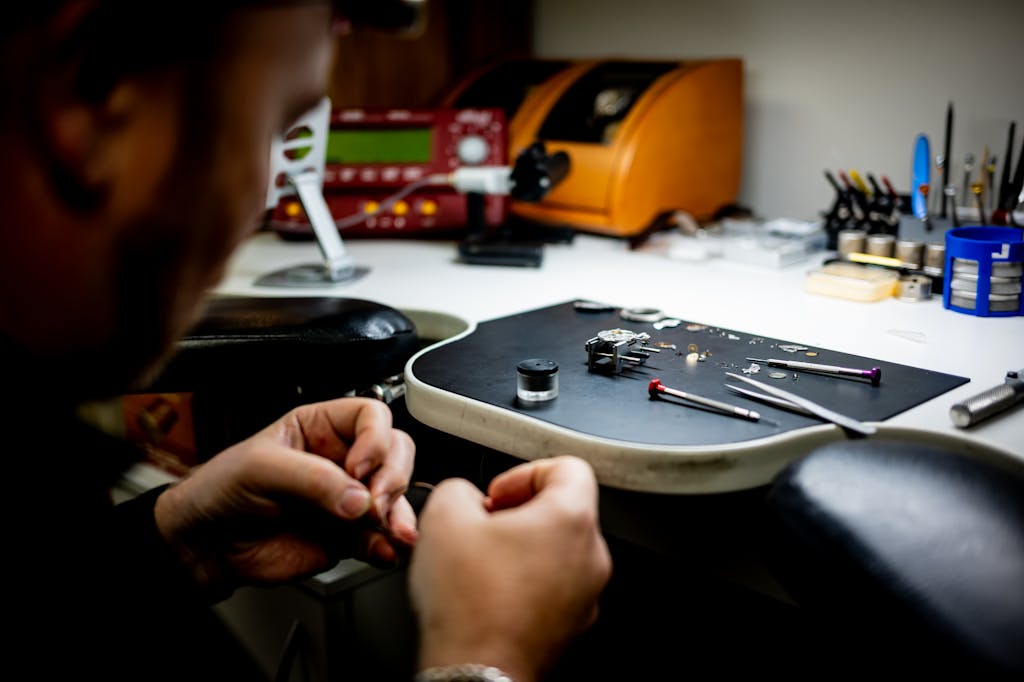 Watchmaker carefully assembling watch components on a workbench, showcasing attention to detail and craftsmanship.